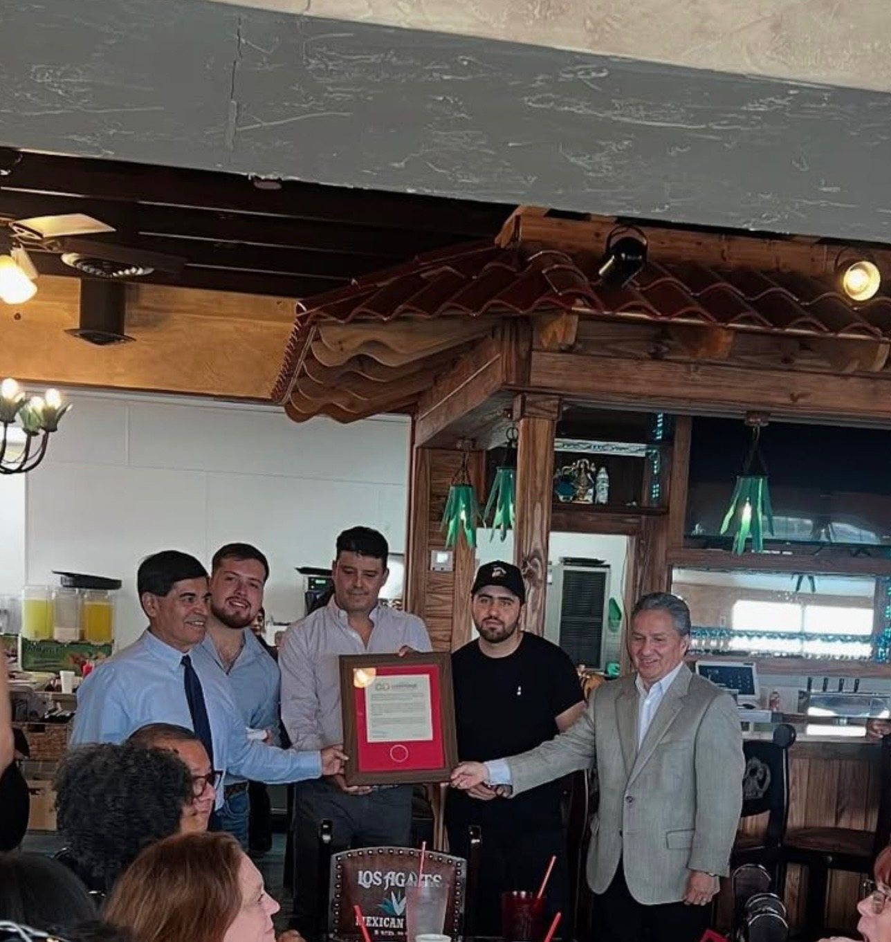 The Los Agaves family and the Mayor of Converse holding the City of Converse proclamation at the bar